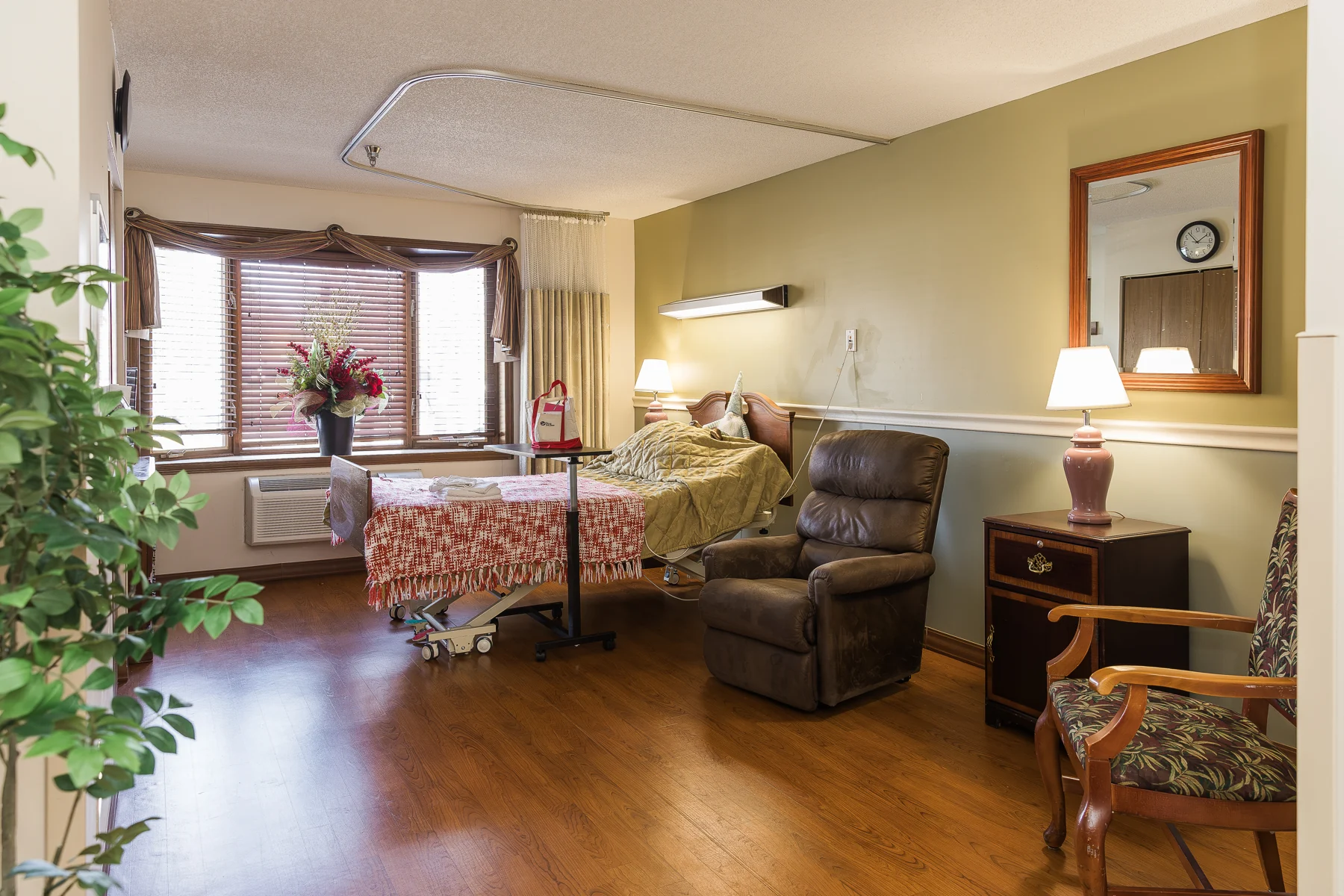 A furnished care suite with a bed and recliner