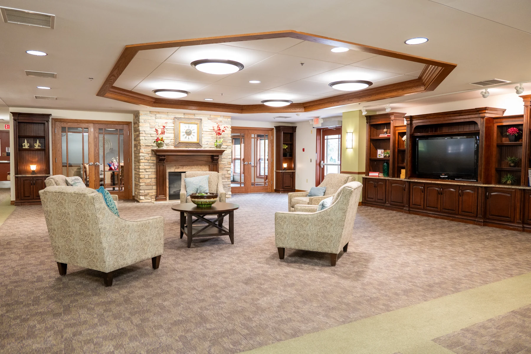 Community lounge with a stone fireplace and comfortable seating